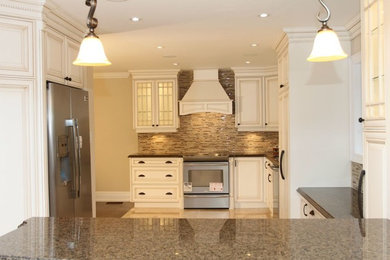 Mid-sized elegant u-shaped porcelain tile and yellow floor eat-in kitchen photo in Toronto with a double-bowl sink, quartz countertops, brown backsplash, ceramic backsplash, stainless steel appliances, no island, white cabinets and raised-panel cabinets