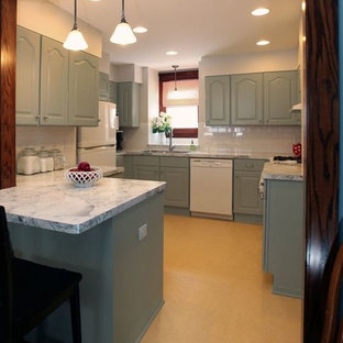 This is an example of a traditional u-shaped eat-in kitchen in Minneapolis with an integrated sink, raised-panel cabinets, grey cabinets, laminate benchtops, white splashback, subway tile splashback and white appliances.