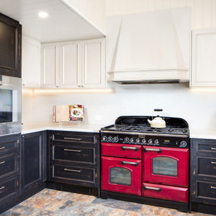 Mid-sized traditional u-shaped open plan kitchen in Other with a farmhouse sink, shaker cabinets, distressed cabinets, quartz benchtops, white splashback, engineered quartz splashback, coloured appliances, ceramic floors, multi-coloured floor, white benchtop and vaulted.