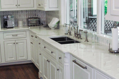 Example of a mid-sized classic l-shaped dark wood floor kitchen design in Raleigh with a double-bowl sink, beaded inset cabinets, white cabinets, marble countertops, gray backsplash, ceramic backsplash and an island