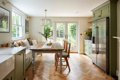 グロスタシャーにある高級な広いトラディショナルスタイルのおしゃれなキッチン (エプロンフロントシンク、シェーカースタイル扉のキャビネット、緑のキャビネット、珪岩カウンター、白いキッチンパネル、セラミックタイルのキッチンパネル、シルバーの調理設備、無垢フローリング、アイランドなし、茶色い床、マルチカラーのキッチンカウンター) の写真