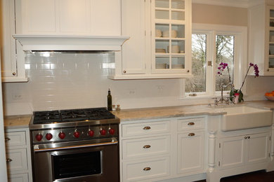 Foto de cocina clásica con puertas de armario blancas, salpicadero blanco, salpicadero de azulejos tipo metro, electrodomésticos de acero inoxidable y suelo de madera oscura