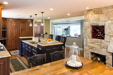 Eat-in kitchen - mid-sized traditional l-shaped medium tone wood floor eat-in kitchen idea in Boston with an undermount sink, raised-panel cabinets, dark wood cabinets, granite countertops, stainless steel appliances, an island, beige backsplash and ceramic backsplash