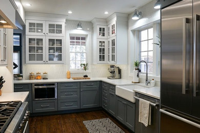 Eat-in kitchen - mid-sized traditional l-shaped dark wood floor and brown floor eat-in kitchen idea in Chicago with a farmhouse sink, recessed-panel cabinets, white cabinets, quartz countertops, white backsplash, cement tile backsplash, stainless steel appliances, a peninsula and white countertops