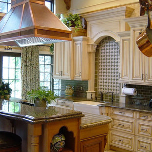 Large traditional enclosed kitchen ideas - Large elegant enclosed kitchen photo in New York with subway tile backsplash, a farmhouse sink, raised-panel cabinets, granite countertops, paneled appliances, beige cabinets and green backsplash