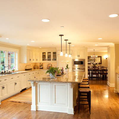 Kitchen - traditional l-shaped medium tone wood floor kitchen idea in Seattle with granite countertops, recessed-panel cabinets, white cabinets, paneled appliances, an undermount sink, white backsplash, ceramic backsplash and an island