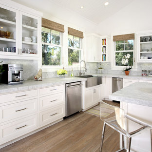 Elegant kitchen photo in San Francisco with glass-front cabinets, stainless steel appliances and a farmhouse sink