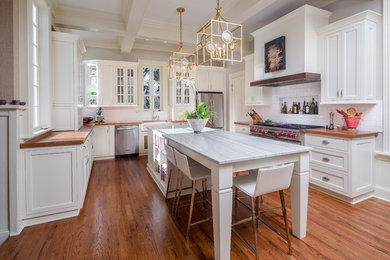 Example of a large classic u-shaped medium tone wood floor eat-in kitchen design in Atlanta with a farmhouse sink, white cabinets, white backsplash, stainless steel appliances, an island, shaker cabinets, quartzite countertops and subway tile backsplash