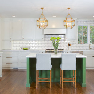 This is an example of a mid-sized traditional kitchen in Atlanta with shaker cabinets, white cabinets, white splashback, subway tile splashback, stainless steel appliances, medium hardwood floors, with island and orange floor.