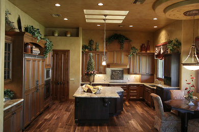 Eat-in kitchen - traditional u-shaped eat-in kitchen idea in Phoenix with an undermount sink, brown cabinets, granite countertops and paneled appliances