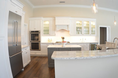 Inspiration for a mid-sized transitional u-shaped dark wood floor open concept kitchen remodel in Orange County with an undermount sink, recessed-panel cabinets, white cabinets, granite countertops, white backsplash, porcelain backsplash, stainless steel appliances and two islands