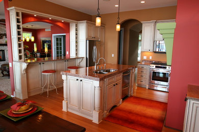 Example of a mid-sized transitional medium tone wood floor kitchen design in Other with an undermount sink, flat-panel cabinets, white cabinets, granite countertops, stainless steel appliances and an island