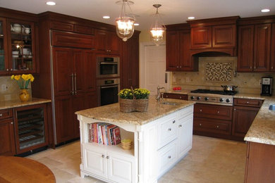 Photo of a medium sized traditional u-shaped kitchen/diner in New York with a built-in sink, raised-panel cabinets, medium wood cabinets, granite worktops, beige splashback, stone tiled splashback, stainless steel appliances, porcelain flooring and an island.