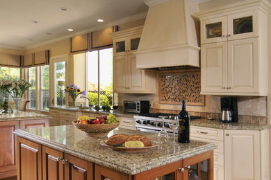 Example of a large trendy galley light wood floor eat-in kitchen design in San Francisco with granite countertops, stainless steel appliances, two islands, an undermount sink, raised-panel cabinets, white cabinets, multicolored backsplash and mosaic tile backsplash