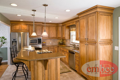 Example of a classic eat-in kitchen design in Other with an undermount sink, raised-panel cabinets, medium tone wood cabinets, quartz countertops, beige backsplash, ceramic backsplash and stainless steel appliances
