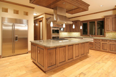Inspiration for a large timeless l-shaped light wood floor kitchen remodel in Edmonton with a farmhouse sink, raised-panel cabinets, medium tone wood cabinets, granite countertops, stainless steel appliances and an island
