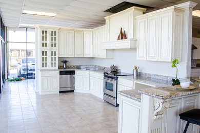 マイアミにあるお手頃価格の広いトランジショナルスタイルのおしゃれなキッチン (シェーカースタイル扉のキャビネット、白いキャビネット、御影石カウンター、白いキッチンパネル、石スラブのキッチンパネル、シルバーの調理設備、セラミックタイルの床、ベージュの床) の写真