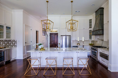 Example of a large transitional u-shaped dark wood floor and brown floor eat-in kitchen design in New Orleans with a farmhouse sink, white cabinets, white backsplash, stone slab backsplash, stainless steel appliances, shaker cabinets, an island, quartzite countertops and white countertops