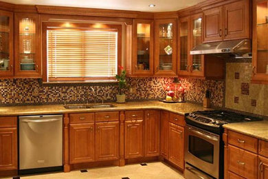 Inredning av ett klassiskt stort kök, med en dubbel diskho, luckor med upphöjd panel, skåp i mellenmörkt trä, granitbänkskiva, beige stänkskydd, stänkskydd i stenkakel, rostfria vitvaror, travertin golv och en köksö