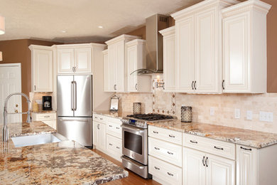 Eat-in kitchen - large traditional u-shaped laminate floor and brown floor eat-in kitchen idea in Toronto with a farmhouse sink, raised-panel cabinets, white cabinets, granite countertops, beige backsplash, ceramic backsplash, stainless steel appliances and an island