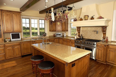 Inspiration for a large timeless l-shaped medium tone wood floor and brown floor open concept kitchen remodel in Orange County with a double-bowl sink, raised-panel cabinets, stainless steel appliances, an island, medium tone wood cabinets, granite countertops, beige backsplash and stone tile backsplash