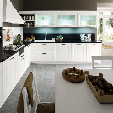 Traditional L-shaped white kitchen with black countertop