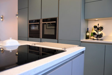 Design ideas for a contemporary kitchen in Surrey with an island.