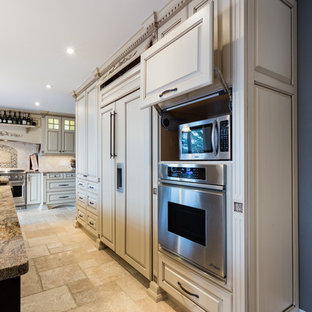 Design ideas for a large traditional kitchen in Other with raised-panel cabinets, beige cabinets, granite benchtops, beige splashback, stone tile splashback, panelled appliances and travertine floors.