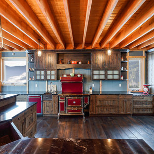 Inspiration for a country kitchen in Vancouver with an undermount sink, louvered cabinets, dark wood cabinets, coloured appliances, dark hardwood floors, with island, brown floor and black benchtop.