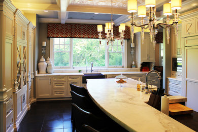 Example of a large transitional single-wall ceramic tile eat-in kitchen design in Other with a farmhouse sink, raised-panel cabinets, white cabinets, solid surface countertops, gray backsplash, stone slab backsplash, stainless steel appliances and an island