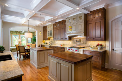 Eat-in kitchen - large traditional u-shaped medium tone wood floor and brown floor eat-in kitchen idea in Atlanta with raised-panel cabinets, brown cabinets, marble countertops, beige backsplash, marble backsplash, two islands, a double-bowl sink and paneled appliances