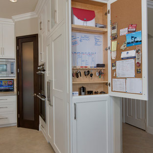 Photo of a mid-sized transitional u-shaped kitchen pantry in San Diego with an undermount sink, recessed-panel cabinets, white cabinets, quartzite benchtops, grey splashback, ceramic splashback, stainless steel appliances, porcelain floors and with island.