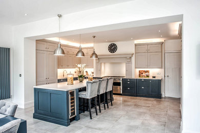 Traditional open plan kitchen in Other with a double-bowl sink, shaker cabinets, blue cabinets, quartz worktops, white splashback, stainless steel appliances, ceramic flooring, an island, grey floors and white worktops.