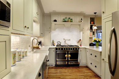 Exempel på ett mellanstort klassiskt kök, med en rustik diskho, luckor med infälld panel, vita skåp, bänkskiva i kvarts, vitt stänkskydd, stänkskydd i keramik, rostfria vitvaror, mellanmörkt trägolv och en halv köksö