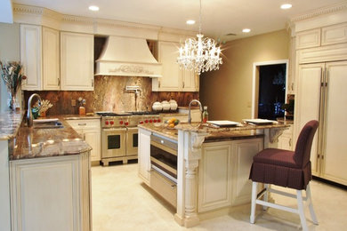 Inspiration for a large timeless l-shaped limestone floor eat-in kitchen remodel in New York with a double-bowl sink, raised-panel cabinets, white cabinets, granite countertops, brown backsplash, stone slab backsplash, stainless steel appliances and an island