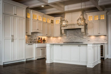 Example of a mid-sized classic l-shaped dark wood floor eat-in kitchen design in DC Metro with a farmhouse sink, recessed-panel cabinets, white cabinets, marble countertops, gray backsplash, matchstick tile backsplash, paneled appliances and an island