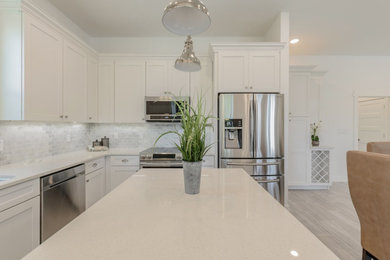 Example of a mid-sized classic ceramic tile and gray floor eat-in kitchen design in Tampa with shaker cabinets, white cabinets, quartzite countertops, gray backsplash, ceramic backsplash, stainless steel appliances, an island and white countertops