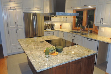 Modelo de cocina clásica de tamaño medio con armarios con paneles con relieve, puertas de armario blancas, encimera de granito y una isla