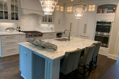 Example of a large classic l-shaped medium tone wood floor and brown floor eat-in kitchen design in Atlanta with an undermount sink, raised-panel cabinets, white cabinets, marble countertops, white backsplash, marble backsplash, stainless steel appliances, an island and white countertops
