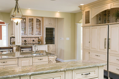 Huge elegant u-shaped dark wood floor and brown floor enclosed kitchen photo in Philadelphia with an undermount sink, raised-panel cabinets, white cabinets, granite countertops, beige backsplash, porcelain backsplash, stainless steel appliances, an island and beige countertops