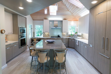 Imagen de cocinas en U moderno grande con fregadero encastrado, salpicadero verde, una isla y armarios con paneles lisos