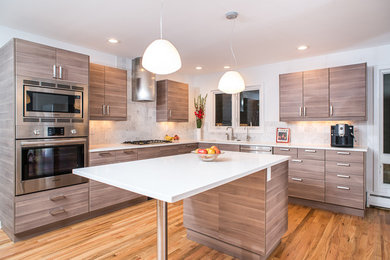This is an example of a medium sized midcentury u-shaped open plan kitchen in Detroit with a submerged sink, flat-panel cabinets, medium wood cabinets, composite countertops, white splashback, ceramic splashback, stainless steel appliances, medium hardwood flooring, an island and brown floors.