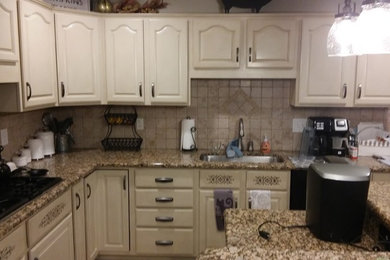 Photo of a classic kitchen in Detroit with raised-panel cabinets, beige cabinets and an island.