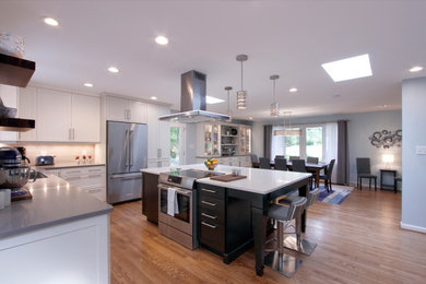 Eat-in kitchen - large l-shaped eat-in kitchen idea in Raleigh with shaker cabinets, white cabinets, stainless steel appliances and an island