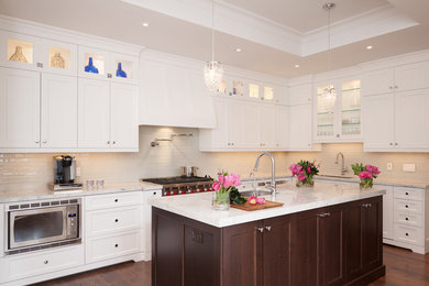 Transitional medium tone wood floor kitchen photo in Toronto with an undermount sink, recessed-panel cabinets, white cabinets, quartzite countertops, gray backsplash, glass tile backsplash, stainless steel appliances and an island