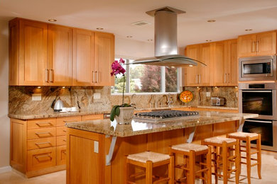 Eat-in kitchen - large transitional l-shaped travertine floor and beige floor eat-in kitchen idea in San Diego with an undermount sink, shaker cabinets, medium tone wood cabinets, granite countertops, beige backsplash, stone slab backsplash, stainless steel appliances and an island
