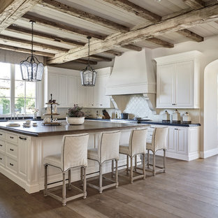 Esempio di una grande cucina tradizionale con ante con bugna sagomata, paraspruzzi beige, ante bianche, lavello stile country, top in saponaria, paraspruzzi con piastrelle in ceramica, pavimento in legno massello medio e pavimento marrone