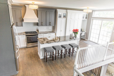 Inspiration for a mid-sized transitional l-shaped medium tone wood floor eat-in kitchen remodel in Philadelphia with a farmhouse sink, shaker cabinets, white cabinets, quartz countertops, gray backsplash, porcelain backsplash, stainless steel appliances and an island