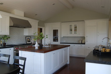 Example of a transitional u-shaped eat-in kitchen design in San Francisco with shaker cabinets, white cabinets, white backsplash and paneled appliances