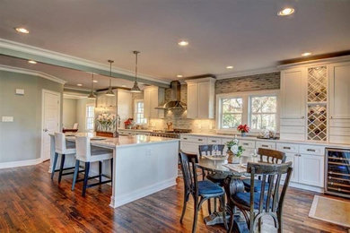 Mid-sized transitional single-wall medium tone wood floor eat-in kitchen photo in Nashville with an undermount sink, beaded inset cabinets, white cabinets, quartz countertops, green backsplash, porcelain backsplash, stainless steel appliances and an island
